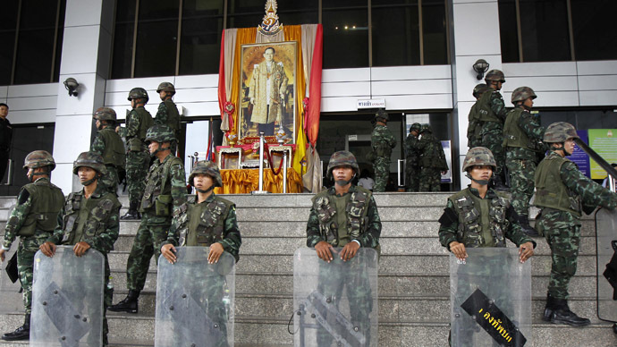 Thai soldiers stand guard at the criminal court in front of a portrait of Thailand's King Bhumibol Adulyadej in Bangkok May 26, 2014. (Reuters)