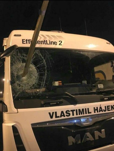 A Czech truck driver passing through Calais has narrowly avoided being killed by migrants when they hurled a long wooden stake through the window of his cab before mobbing his vehicle