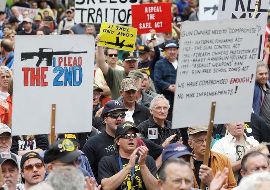 Gun-rights activists hold signs during a Second Amendment rally Tuesday, June 11, 2013, in Albany, N.Y. More than 1,000 demonstrators filled a park outside the Capitol calling for repeal of New York's new gun law.